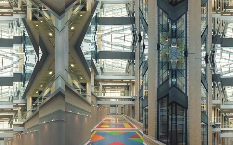 Symmetrical digital collage of MIT’s Building 46 atrium, featuring Sol LeWitt’s Bars of Color within Squares (2007) painted on the floor. The mirrored composition multiplies the geometric ceiling, glass walkways, and colorful floor patterns into a kaleidoscopic architectural view that emphasizes rhythm, repetition, and light.